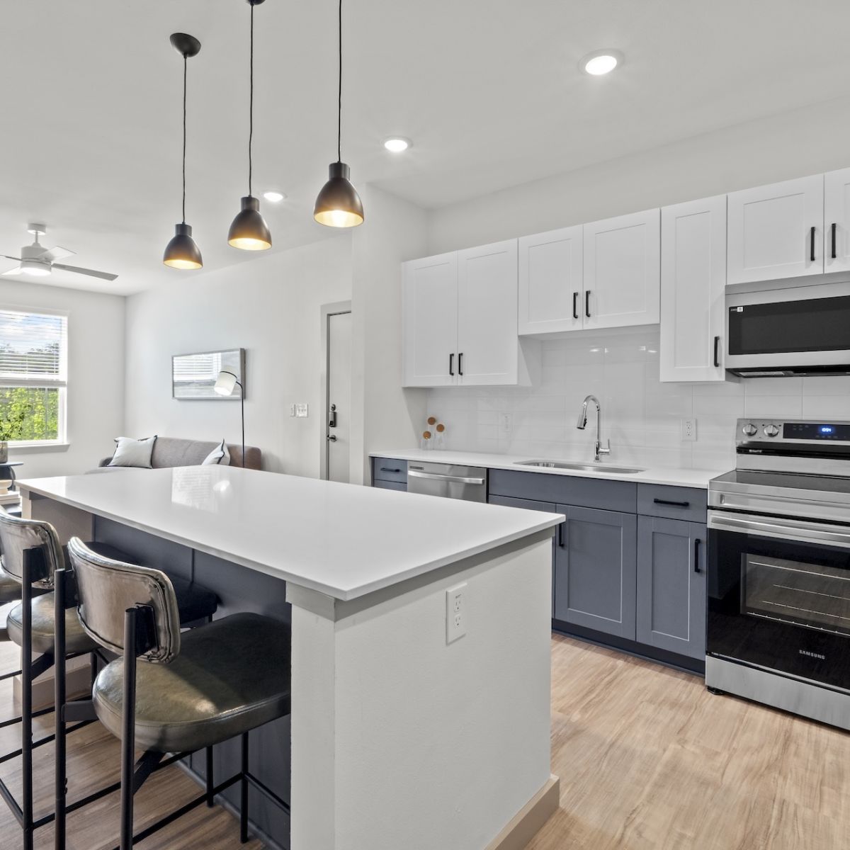 Modern Apartment Kitchen with stainless steel appliances, two-toned cabinetry, and quartz countertops in Austin TX