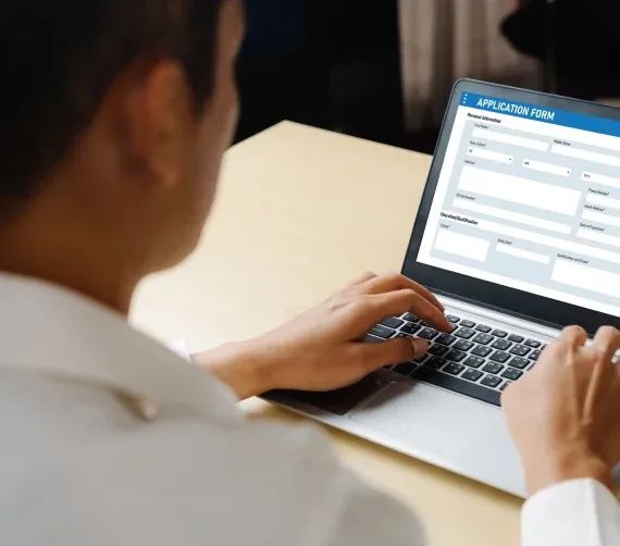 Sierra on 66 Person filling out an online application form on a laptop at a desk.