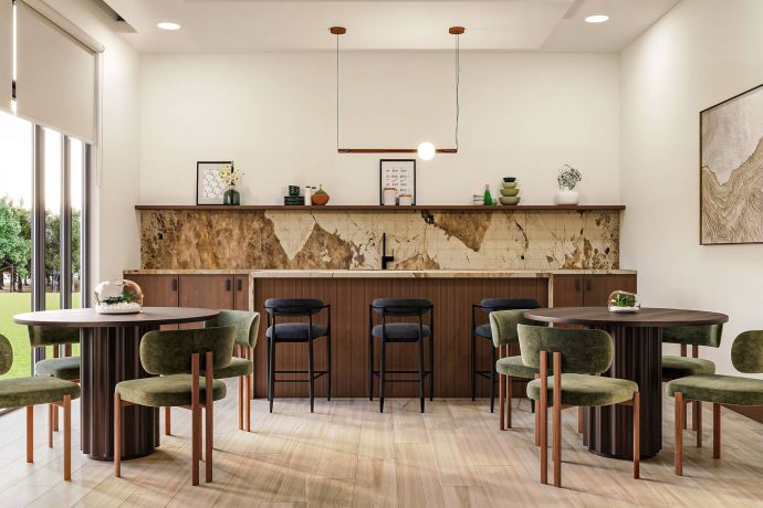 Allers Landing Modern cafe with round tables, green chairs, bar seating, large windows, and minimalist decor.